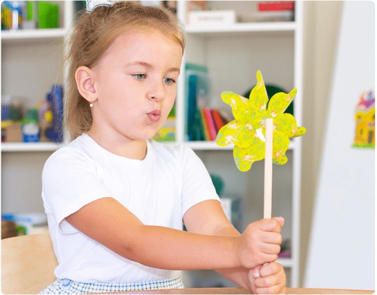 A Girl practicing the blowing technique as a part of Speech therapy