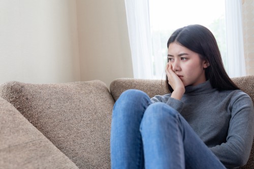 A lady sitting sad and unable to decide