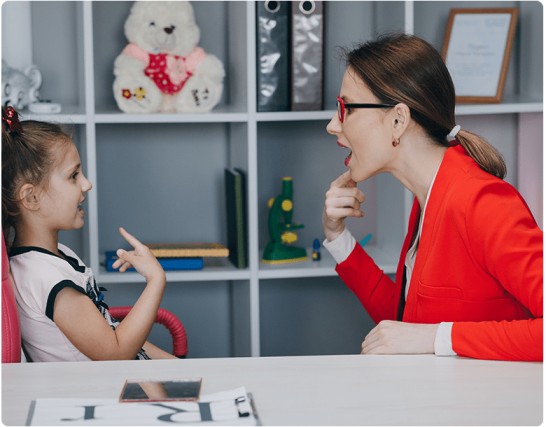 Speech therapist training a child