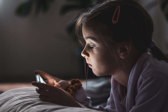 A girl child using cellphone at night