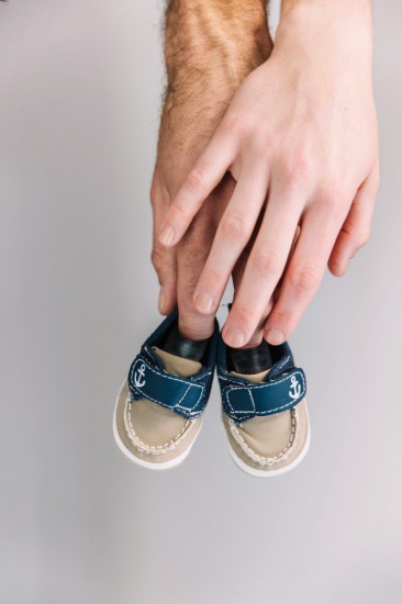 A Couple holding baby shoes