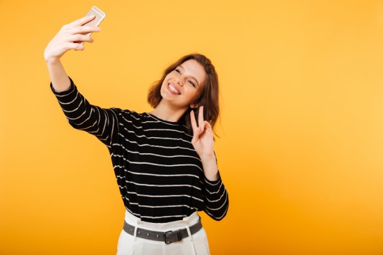 A girl taking a selfie smiling at the camera