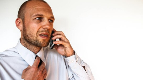 A worried man speaking over the phone