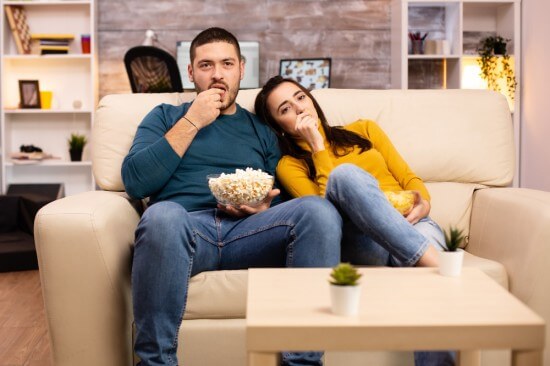 Couple watching TV and having popcorn