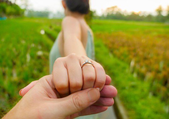 An engaged couple holding hands